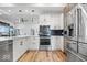 Well-lit kitchen with stainless steel appliances, white cabinets, and hardwood floors at 244 N Summit St, Indianapolis, IN 46201