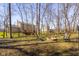 Spacious backyard featuring a fire pit surrounded by natural landscaping and views of the home and wooded area at 2895 Prairie Stream Way, Columbus, IN 47203