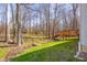 Backyard with a small stream and bridge leading to a wooden deck area surrounded by mature trees at 2895 Prairie Stream Way, Columbus, IN 47203