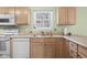 Traditional kitchen featuring wooden cabinets, stainless steel sink, and a window at 2895 Prairie Stream Way, Columbus, IN 47203