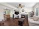 Cozy living room with a fireplace, hardwood floors, comfortable seating, and an adjacent dining area at 2895 Prairie Stream Way, Columbus, IN 47203