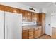 Kitchen with wooden cabinets, white refrigerator, and laminate countertops at 298 Northridge Dr, Mooresville, IN 46158