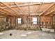 Unfinished basement with exposed ceiling beams and wooden walls, offering potential for customization and ample storage at 3451 N County Road 100 E, Danville, IN 46122