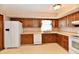 A well-lit kitchen features wood cabinets, a white refrigerator, and essential appliances for convenient meal preparation at 3451 N County Road 100 E, Danville, IN 46122