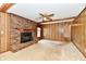 Living room with wood paneling, brick fireplace, and a ceiling fan, providing a cozy and inviting atmosphere at 3451 N County Road 100 E, Danville, IN 46122