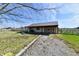 Charming outbuilding featuring a covered porch and gravel driveway, surrounded by green fields at 3451 N County Road 100 E, Danville, IN 46122