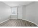 Well-lit bedroom featuring hardwood floors, a window with blinds, and a white door at 3710 Orchard Ave, Indianapolis, IN 46218