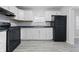 Well-lit kitchen with white cabinets, black appliances, and gray flooring, creating a clean, modern feel at 3710 Orchard Ave, Indianapolis, IN 46218