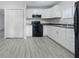 Functional kitchen featuring white cabinetry, black appliances, and easy access to adjacent spaces at 3710 Orchard Ave, Indianapolis, IN 46218