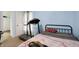 Bright bedroom with a full bed, a treadmill, a guitar, and a doorway to a closet or dressing room at 3940 N Drexel Ave, Indianapolis, IN 46226