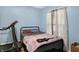 Cozy bedroom with bright blue walls, a comfortable bed, and natural light streaming through the window at 3940 N Drexel Ave, Indianapolis, IN 46226