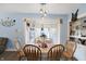 Dining room features wood floors, hanging pendant lights, and a window with white curtains at 3940 N Drexel Ave, Indianapolis, IN 46226