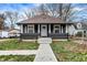 Charming home with a well-manicured front yard and a classic architectural design, columns, and sidewalk entrance at 3940 N Drexel Ave, Indianapolis, IN 46226