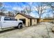 Detached garage with a vehicle in the foreground and gravel driveway, providing ample parking and storage space at 3940 N Drexel Ave, Indianapolis, IN 46226