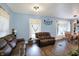 Open-concept living room with two leather sofas, bright lighting, and a glimpse into the dining area and kitchen at 3940 N Drexel Ave, Indianapolis, IN 46226