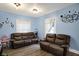 Inviting living room with warm blue walls, comfortable leather sofas, and cozy decor elements at 3940 N Drexel Ave, Indianapolis, IN 46226