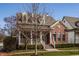 Attractive brick home with a covered front porch and dormer windows set amidst lush, mature landscaping at 4030 Statesmen Dr, Indianapolis, IN 46250