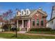 Charming brick home with dormer windows, a covered porch, and manicured lawn in a suburban neighborhood at 4030 Statesmen Dr, Indianapolis, IN 46250