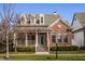 Charming brick home with inviting front porch and manicured landscaping creates a welcoming curb appeal at 4030 Statesmen Dr, Indianapolis, IN 46250