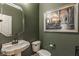 This powder room features dark paint, a decorative mirror, and a two-piece toilet at 4030 Statesmen Dr, Indianapolis, IN 46250