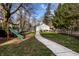 Large backyard featuring a grassy lawn, play set, patio, and fenced area, perfect for outdoor activities and relaxation at 4350 N College Ave, Indianapolis, IN 46205