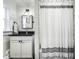Bathroom featuring a vanity with a black countertop, square mirror, and a striped shower curtain at 4350 N College Ave, Indianapolis, IN 46205