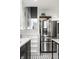 Stainless steel refrigerator alongside stairs with stylish black and white tile flooring at 4350 N College Ave, Indianapolis, IN 46205