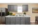 Updated kitchen features gray cabinets, white countertops, stainless steel appliances at 5010 Elliott Ave, Indianapolis, IN 46201