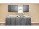 Updated kitchen features gray cabinets, white countertops and stainless steel sink at 5010 Elliott Ave, Indianapolis, IN 46201