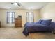 Bright bedroom featuring a ceiling fan, dresser, and a comfortable blue bedspread at 5233 Birmingham Dr, Indianapolis, IN 46235