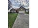 Charming brick home featuring an attached two-car garage and a well-manicured lawn at 5233 Birmingham Dr, Indianapolis, IN 46235