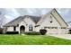 Charming single-Gathering home boasts a well-manicured lawn, arched entryway, three-car garage, and a beautifully landscaped front yard at 5949 Willow Bend Dr, Avon, IN 46123
