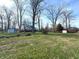 Large backyard with mature trees, green grass, and storage sheds at the edge of the property at 5967 Oak Hill East Dr, Plainfield, IN 46168