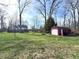 Wide backyard with lush green grass and several mature trees, as well as a storage shed at 5967 Oak Hill East Dr, Plainfield, IN 46168