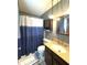 Bathroom features a modern shower curtain, tan vanity with a sink, and a wall cabinet at 5967 Oak Hill East Dr, Plainfield, IN 46168