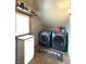 Modern laundry room with overhead storage, modern front load washer and dryer, and neutral colored flooring at 5967 Oak Hill East Dr, Plainfield, IN 46168