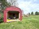 Shed containing lawn equipment and tools, with open doors and a well-maintained lawn at 5967 Oak Hill East Dr, Plainfield, IN 46168