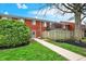 View of the backyard of a brick townhome with green grass and healthy landscaping at 6515 Park Central Way # B, Indianapolis, IN 46260