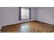 Bright bedroom featuring laminate floors and a window with purple curtains at 6515 Park Central Way # B, Indianapolis, IN 46260
