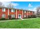 Attractive townhome exterior featuring a brick facade, blue front door, and lush lawn at 6515 Park Central Way # B, Indianapolis, IN 46260