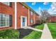 Close-up exterior view featuring a brick townhome with a blue door and green landscaping at 6515 Park Central Way # B, Indianapolis, IN 46260