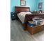 Primary bedroom showcasing an ornate wood sleigh bed and gray wood-look flooring at 6808 Summer Time Dr, Indianapolis, IN 46226