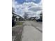 View of complex featuring mature trees, and a cracked asphalt driveway with parked cars at 6808 Summer Time Dr, Indianapolis, IN 46226