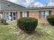 Charming brick and vinyl exterior featuring mature shrubbery, a security door and concrete patio at 6808 Summer Time Dr, Indianapolis, IN 46226