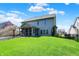 Spacious backyard with a lush lawn, a screened porch, and a beautiful weeping cherry tree at 7233 Capel Dr, Indianapolis, IN 46259