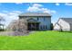 Expansive backyard featuring a well-maintained lawn, screened porch, and a charming weeping cherry tree at 7233 Capel Dr, Indianapolis, IN 46259