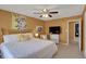 Cozy bedroom featuring warm yellow walls, a queen bed, and a ceiling fan at 7233 Capel Dr, Indianapolis, IN 46259