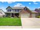 Charming two-story home with a well-manicured lawn and a three car garage at 7233 Capel Dr, Indianapolis, IN 46259