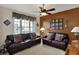 Cozy living room featuring two leather sofas, a ceiling fan and large windows at 7233 Capel Dr, Indianapolis, IN 46259
