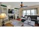 Inviting living room features a fireplace, built-in shelving, ceiling fan and a large window for natural light at 7233 Capel Dr, Indianapolis, IN 46259